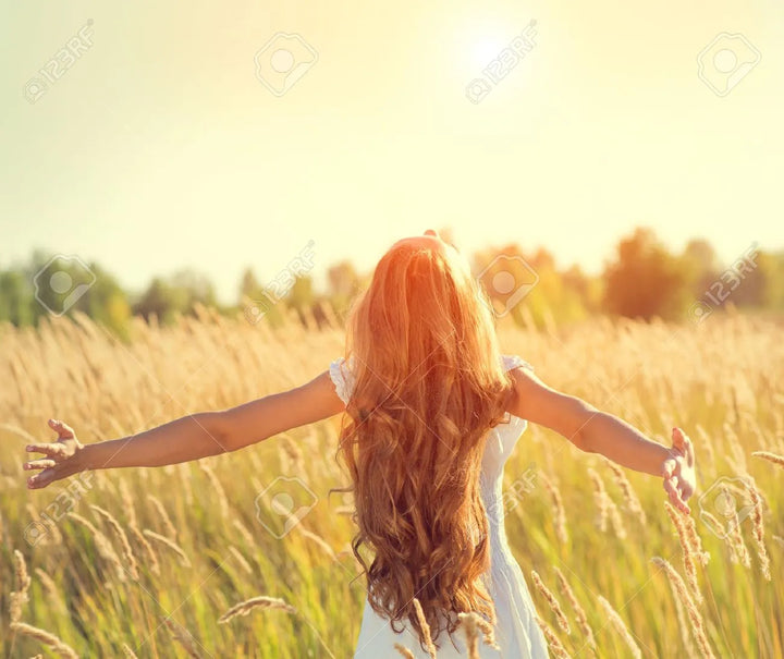 lady walking with curly hair in the grass field