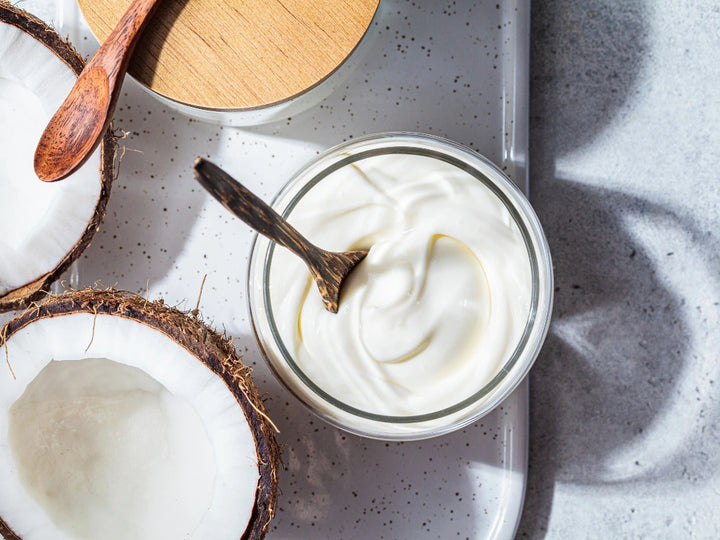 top view, bowl of yoghurt next to half a coconut 