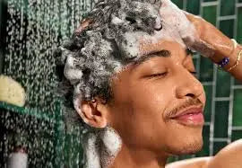 man shampooing her hair in the shower