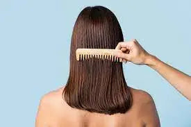 woman brushing through her healthy hair