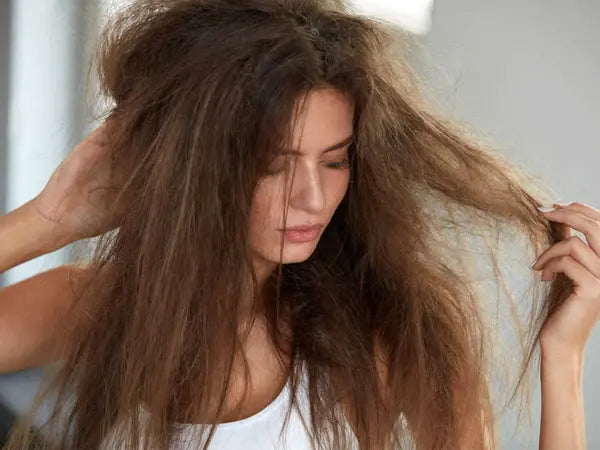 woman touching her frizzy hair