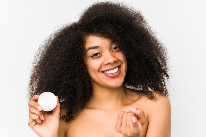 woman with curly hair holding O'right curl cream