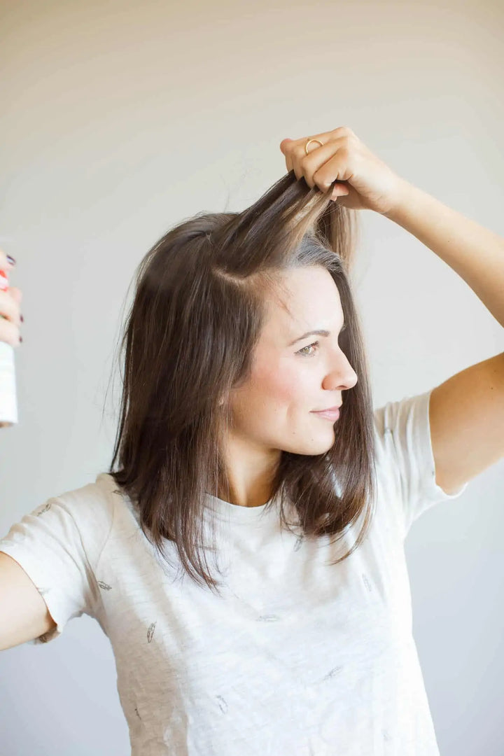 lady applying dry shampoo