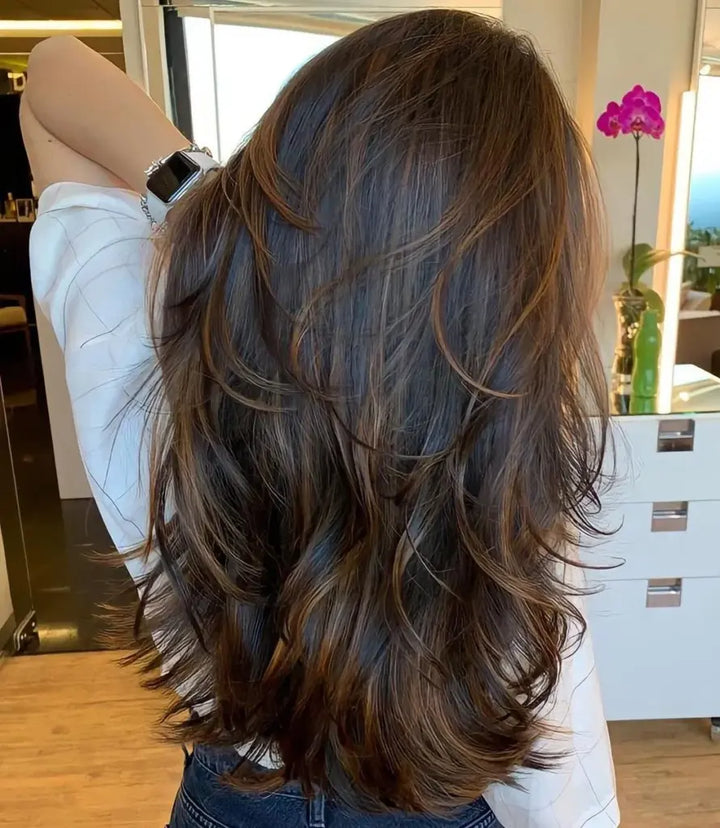 the back of a lady with long, brown hair 