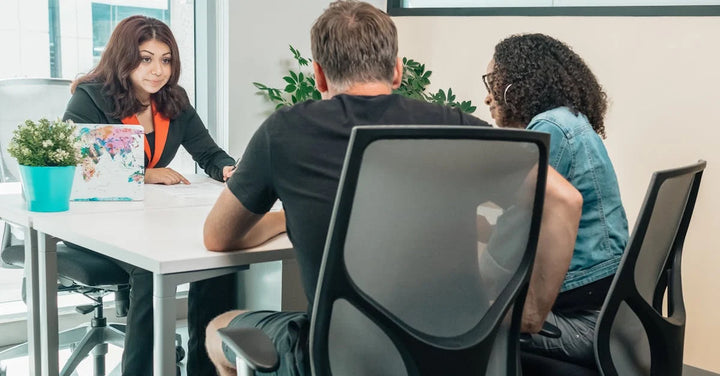 three people having a meeting in a room