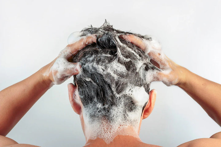 men shampooing his head backview