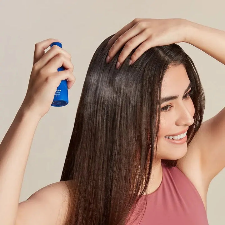 woman spraying dry shampoo